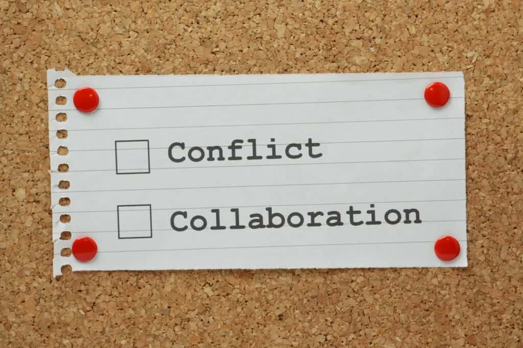 Note paper on a cork board with a list depicting choice between conflict and collaboration.