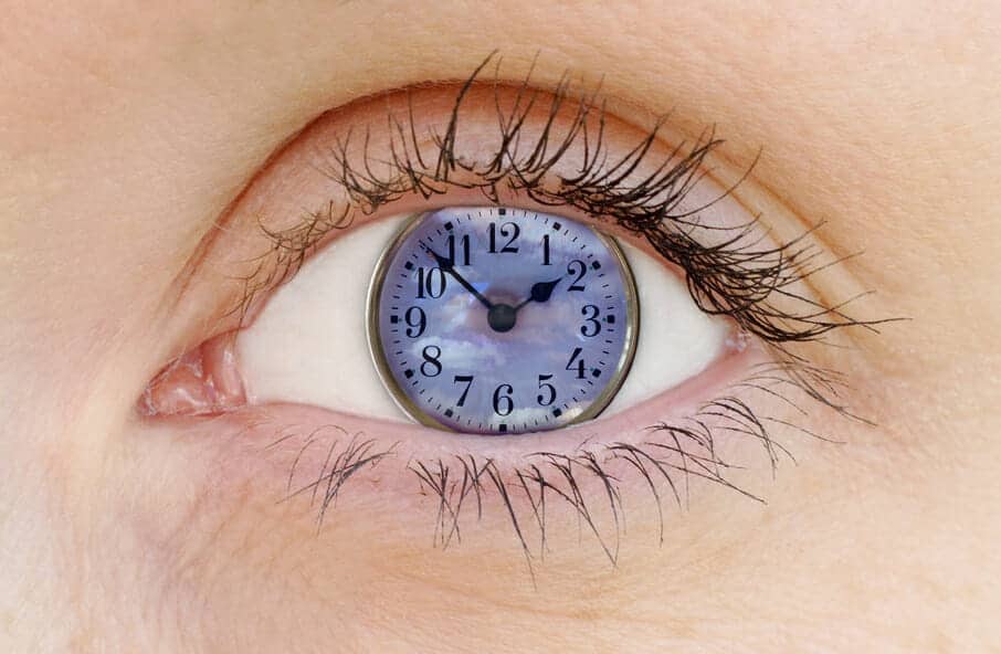 Close up of an eye with a clock in it: take your time