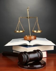 Scales of justice sitting on law books with judge's gavel nearby