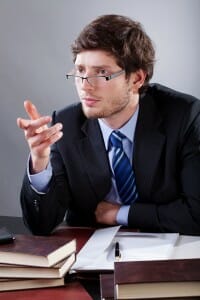 Young Illinois Divorce Lawyer sitting at a table with law books pointing at client.