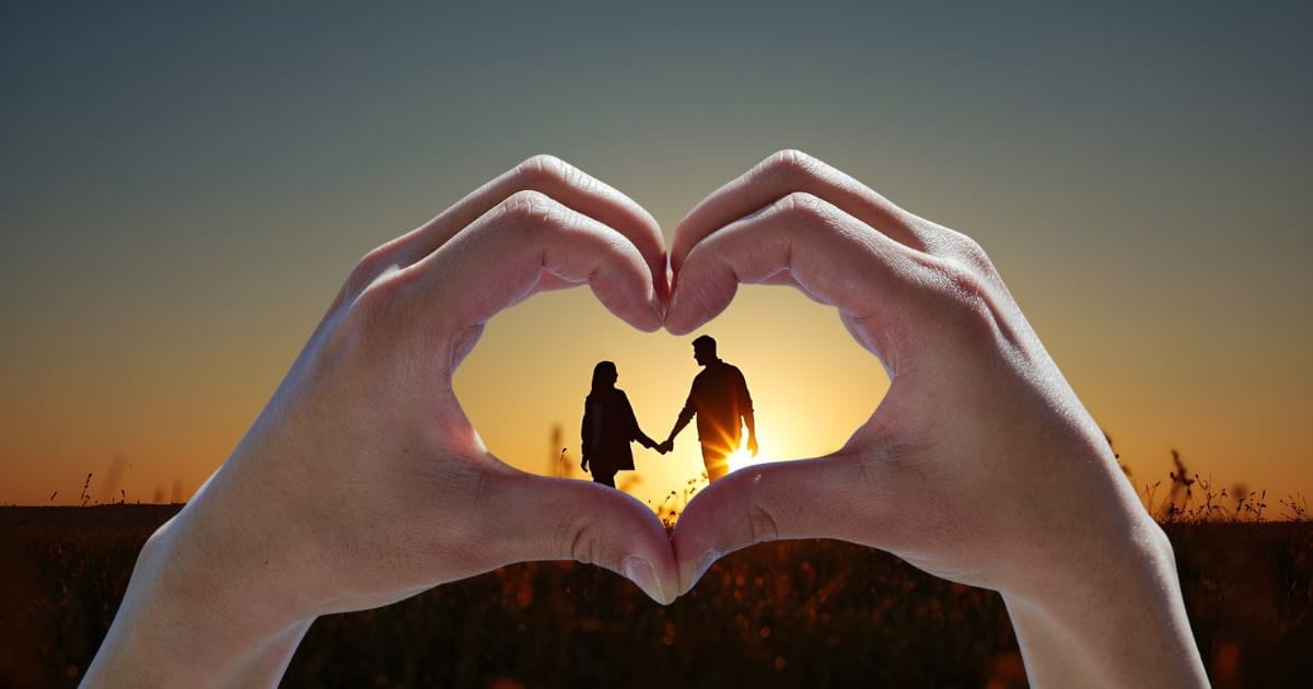finding love again Silhouette of a couple on a hill framed by two hands forming a heart