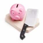 Piggy bank and butcher knife on a chopping block