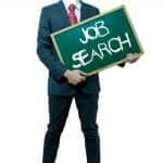 Man holding green board with the words "Job Search" written on it in chalk
