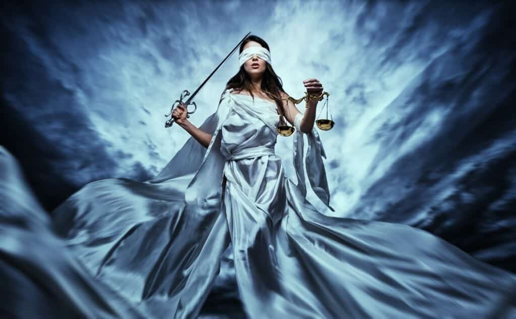 Beautiful blindfolded lady justice holding a sword and the scales of justice.