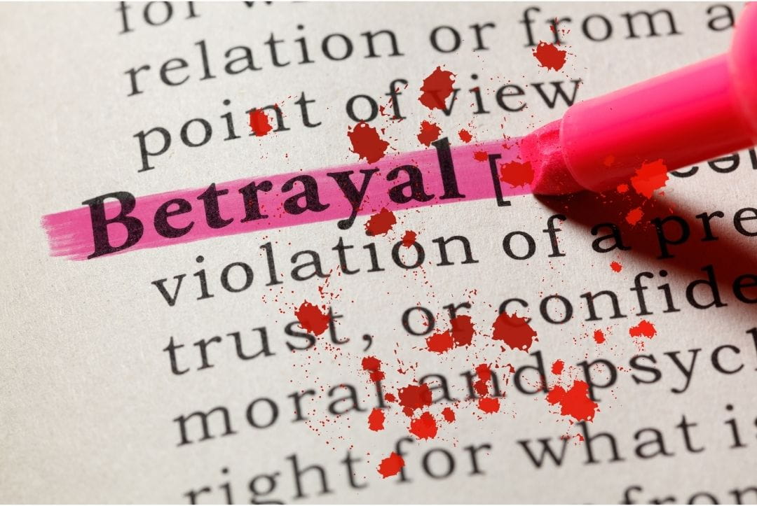 The word betrayal on a dictionary page, highlighted with a pen. The page has blood splatters all over it