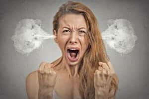 Closeup portrait angry young woman blowing steam coming out of ears, having nervous atomic breakdown, screaming isolated grey wall background. Negative human emotion facial expression feeling attitude