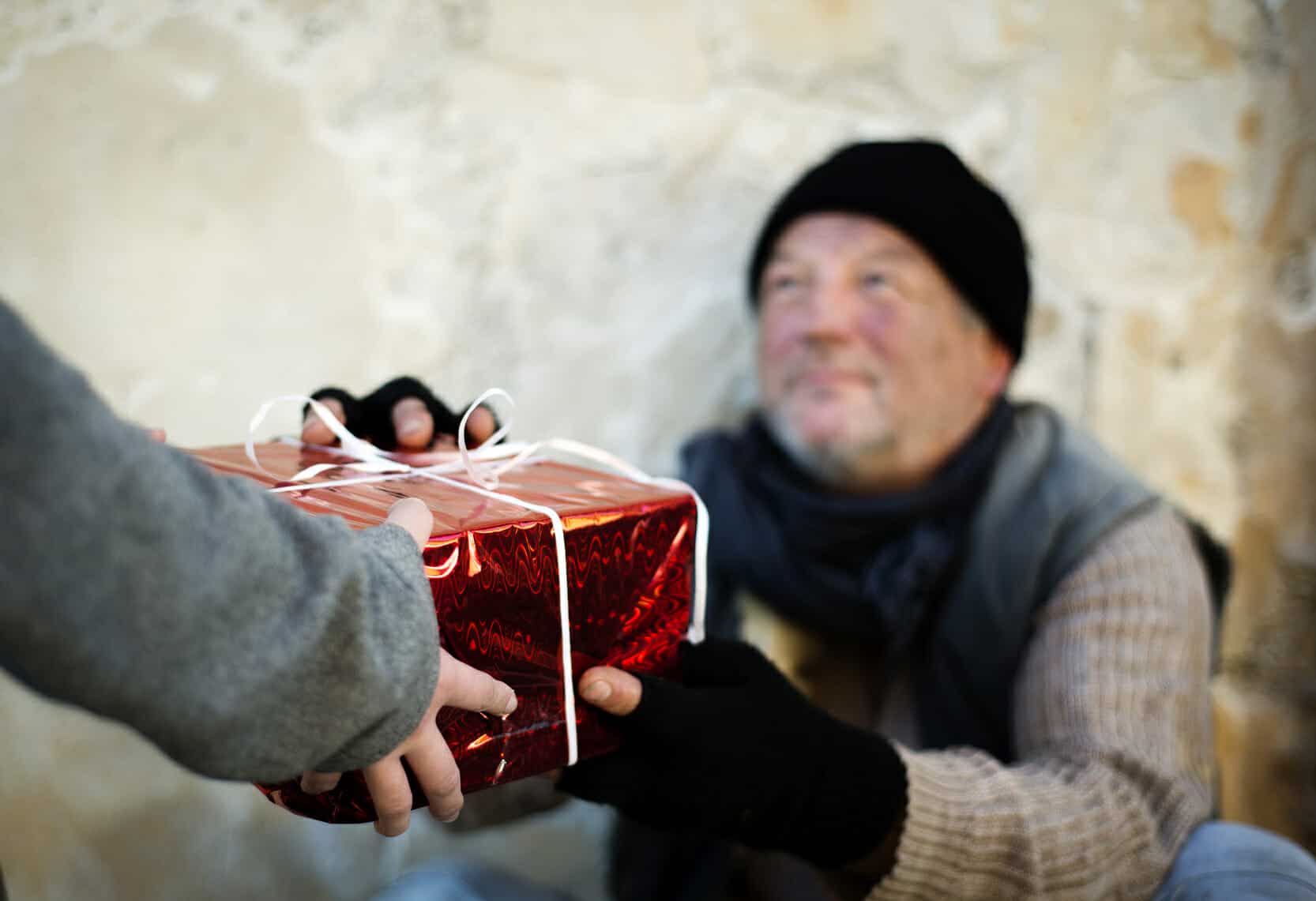 Homeless man accepting Christmas present.