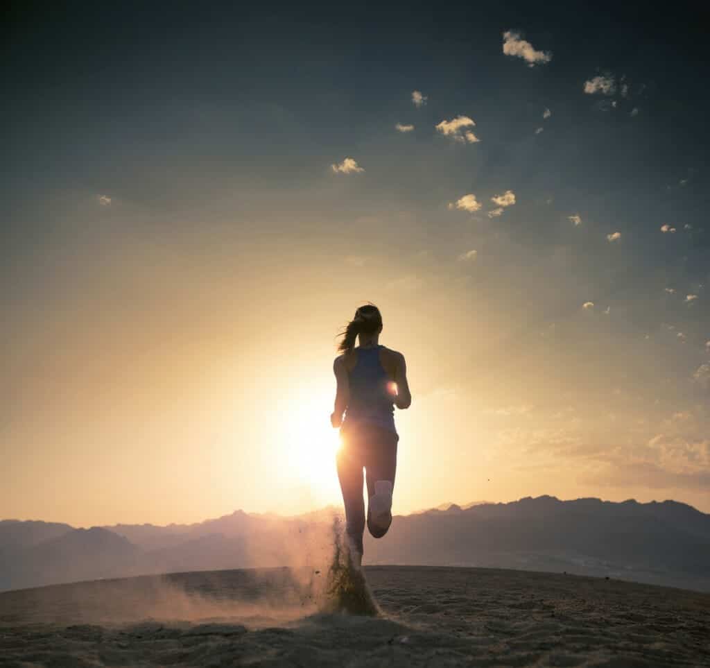 Woman running in the sunrise.