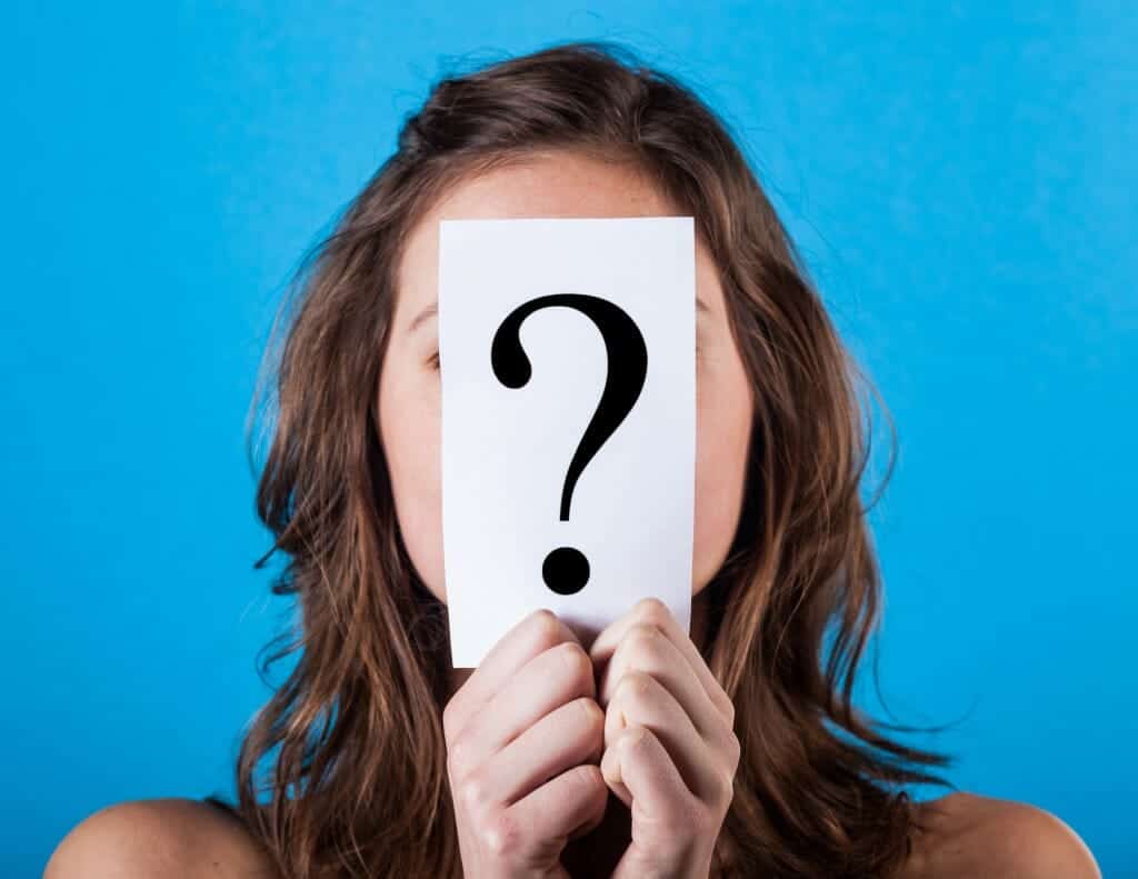 Woman thinking about divorce and holding a paper with a Big Question Mark on it,.