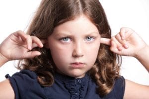 How NOT to tell your kids about divorce. Small sad girl with her fingers in her ears.