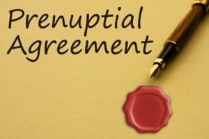 Yellow paper with the words "Prenuptial Agreement," along with a fountain pen and a red seal.