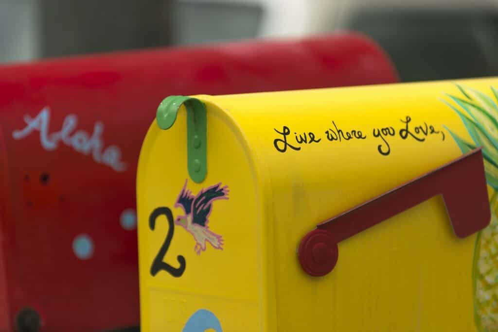 Red and yellow rustic mailboxes. "Live Where You Love" is written on one of them.