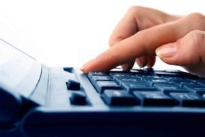 Close up of fingers on a calculator; woman calculating child support.