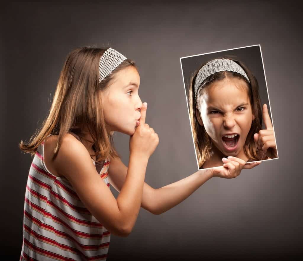 Young girl shushing a photo of herself screaming