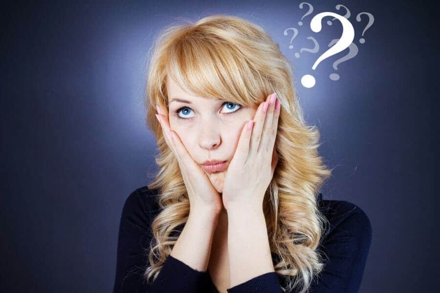 Perplexed woman holding her face with a question mark above her head.