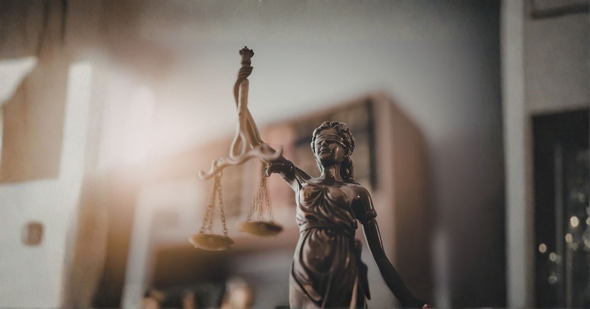 AI image of scales of lady justice in a courtroom setting