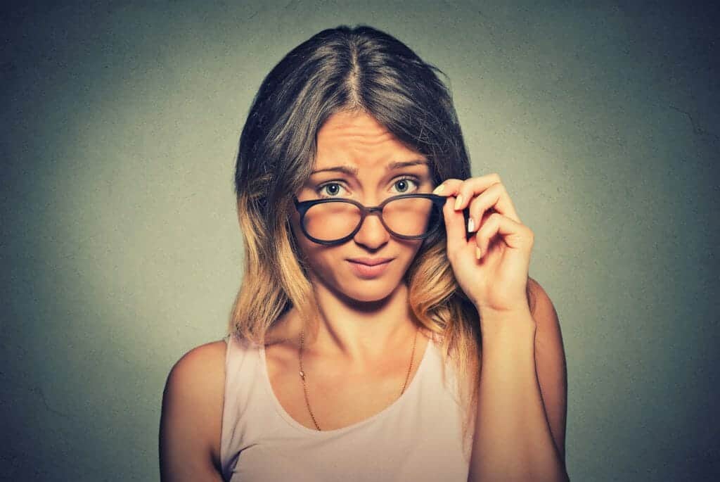 Woman looking over her glasses wondering how to choose a divorce lawyer