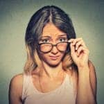 Woman looking over her glasses wondering how to choose a divorce lawyer
