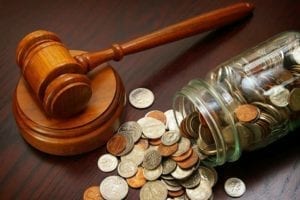 Judge's gavel next to mason jar of coins spilling onto the table. Dating during divorce will cost you.