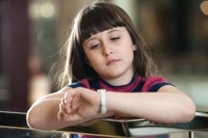 Sad little girl looking at her watch. Make time for your kids!