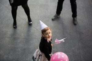 Small girl with a pink balloon, standing between two divorced parents.