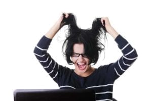 Frustrated woman screaming and pulling her hair because her spouse won't sign divorce papers