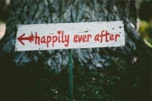 Wooden sign with an arrow pointing to "happily ever after."