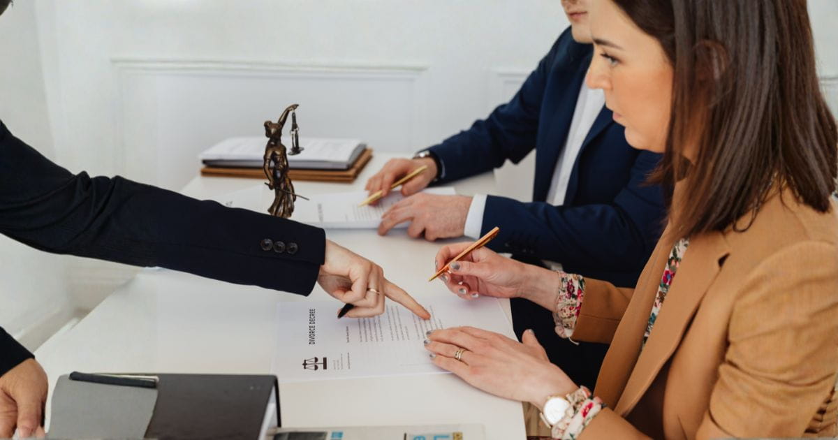 signing papers with divorce lawyer AI image of a couple signing some papers at a divorce lawyer's desk