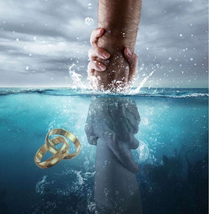 A hand reaches out to clasp another hand drowning in the ocean. Beside are wedding rings, also drowning