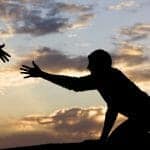 Silhouette of a hand reaching out to help a man get up. Divorce Counseling and Support concept.