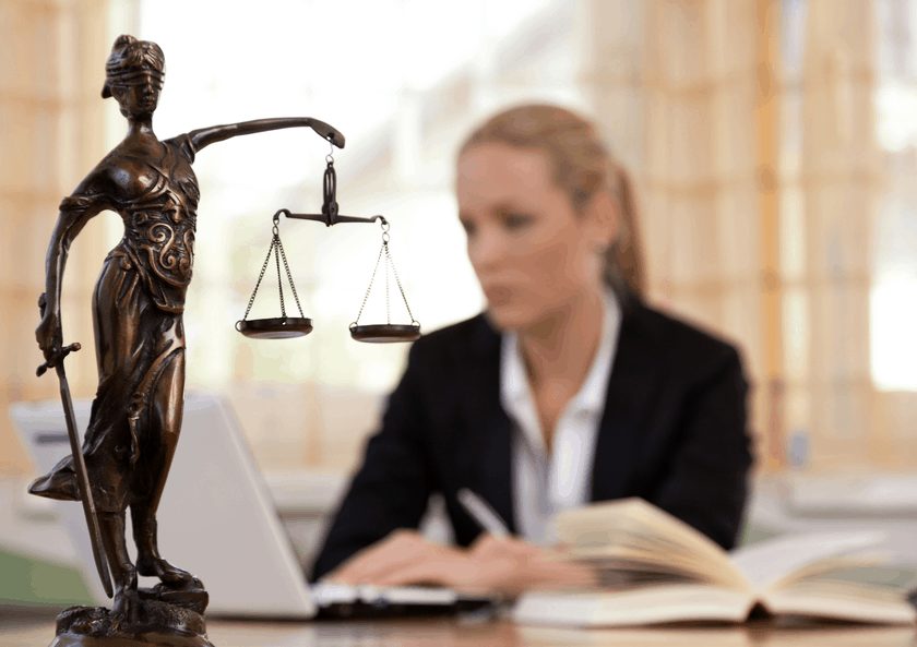 Scales of justice in front of a female lawyer: Do you need a divorce lawyer?