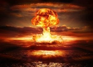 Explosion. Burning orange mushroom cloud over the ocean.