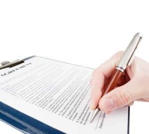 Close up of a hand signing a document.