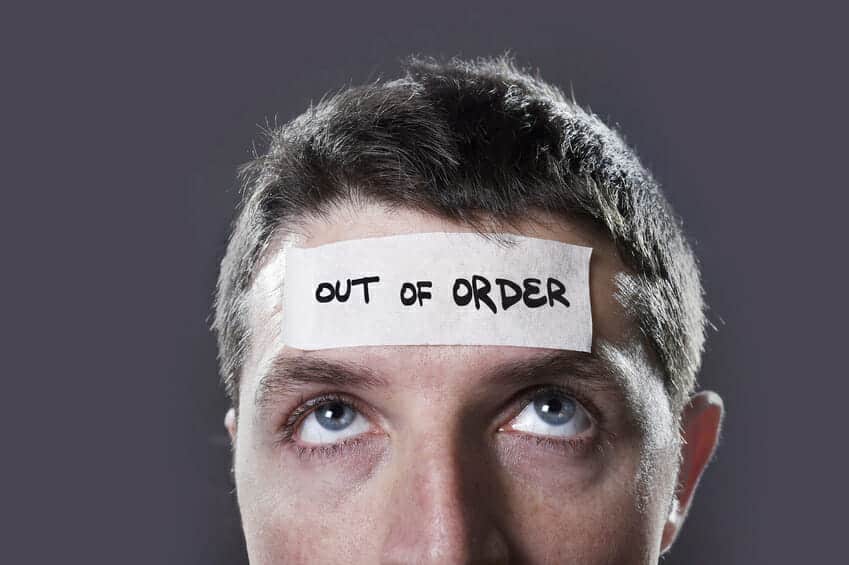 Close up of a man with an "Out of Order" sticker on his forehead