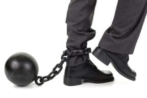 Businessman with ball and chain around his ankle