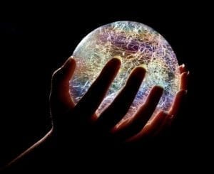 Hands holding a glowing crystal ball.