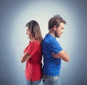 Upset, young divorcing couple standing with their backs to each other