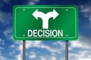 Green sign with white arrows pointing in both directions signifying confused decision.