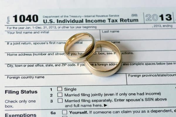 Wedding rings on tax return signifying divorce and taxes.