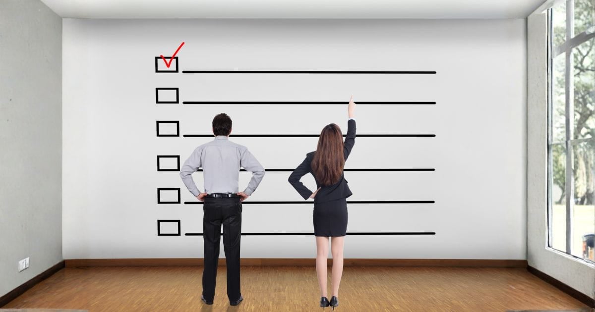 A man and woman looking at a giant checklist on a wall. Planning in Divorce