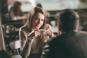 Smiling woman having coffee and emotional affair with a man