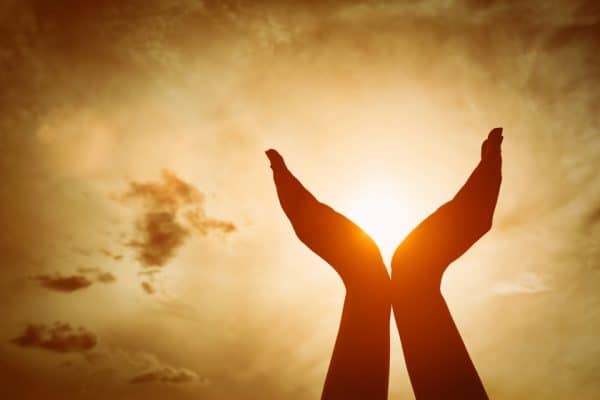 Uplifted hands with the sun shining through designating faith based divorce support groups