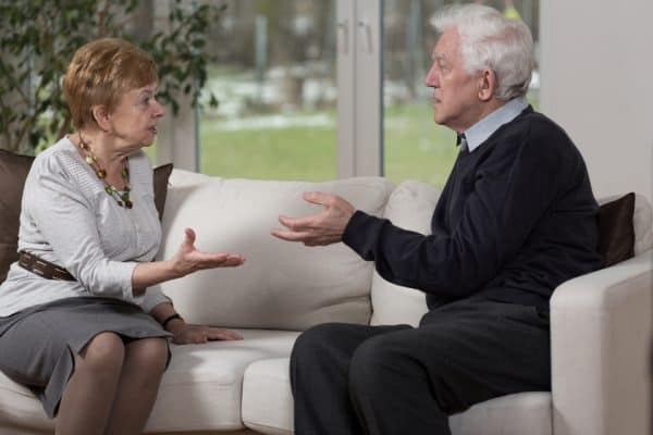 Senior couple going through a gray divorce arguing on a couch