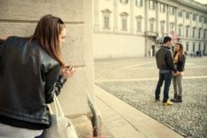 Woman spying on her cheating husband holding hands with another woman