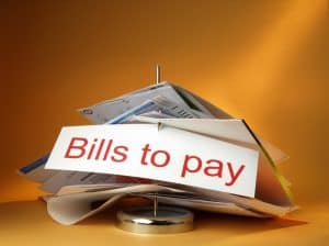 Stack of bills on a spindle with sign "Bills to Pay" in red letters.