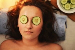 Woman relaxing with cucumber slices on her eyes