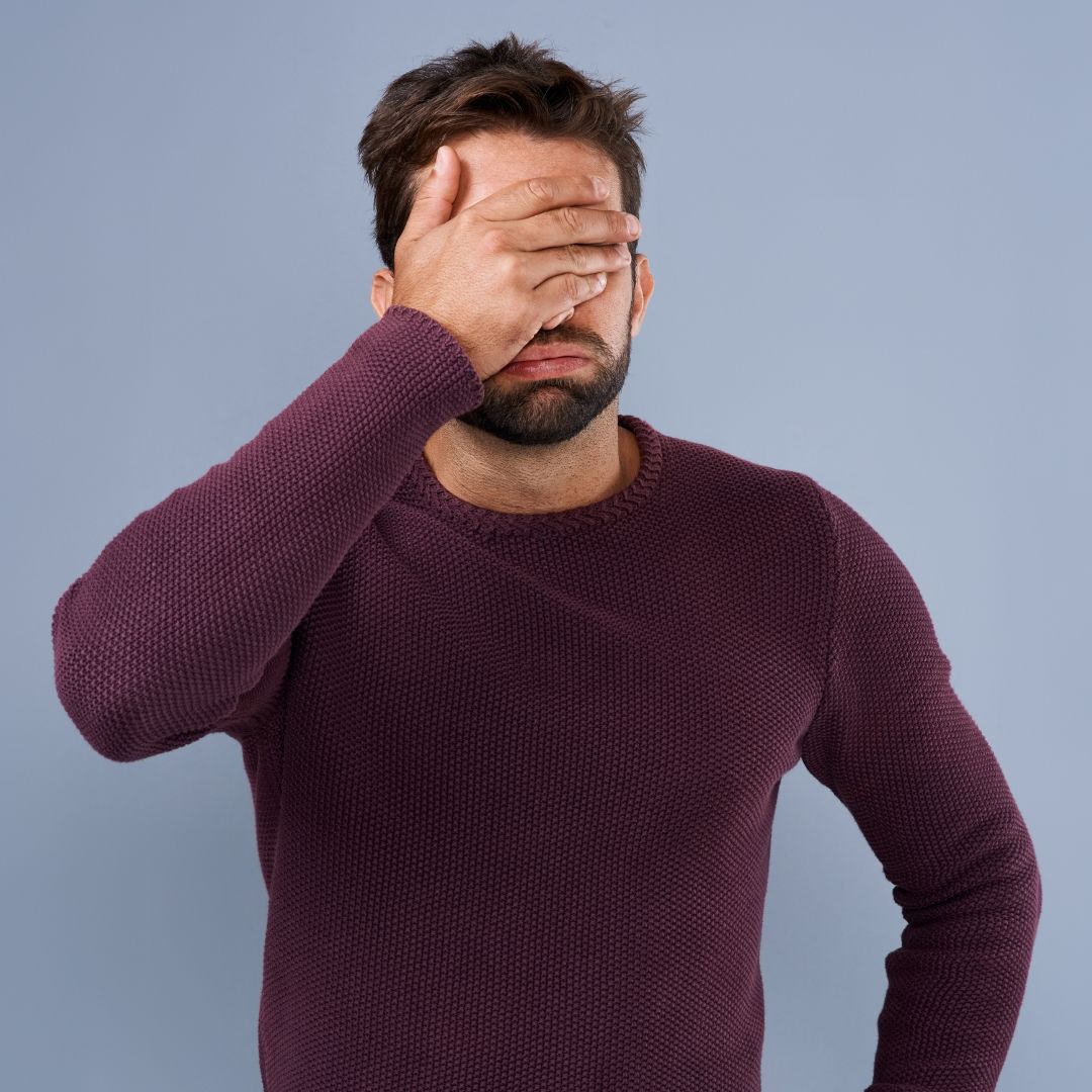 Man who realized he made divorce mistakes with his hand over his forehead.