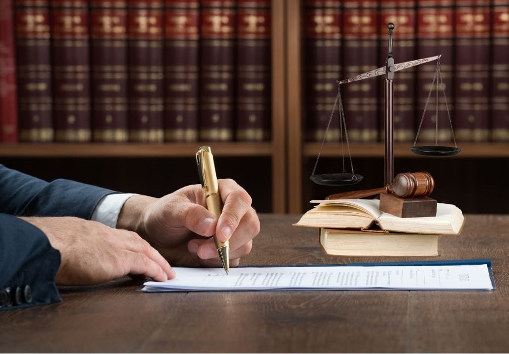 writing a legal document A hand writing a legal document on a desk