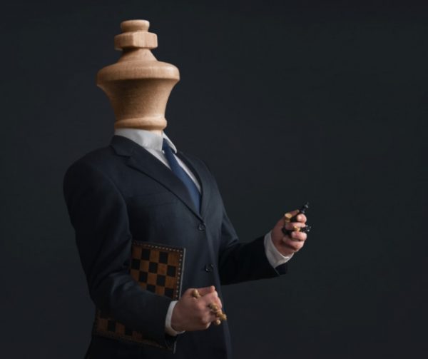 Businessman with head of a wooden chess king carrying chessboard and pieces. This is what divorcing a narcissist is like