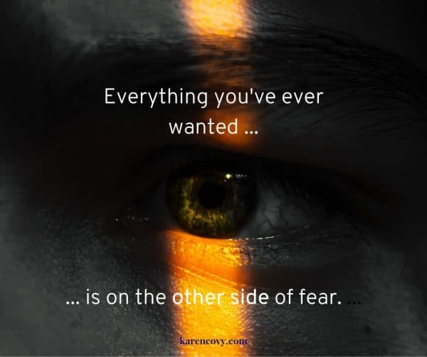 Close up of an eye peering through the darkness with a quote: Everything you've ever wanted is on the other side of fear.